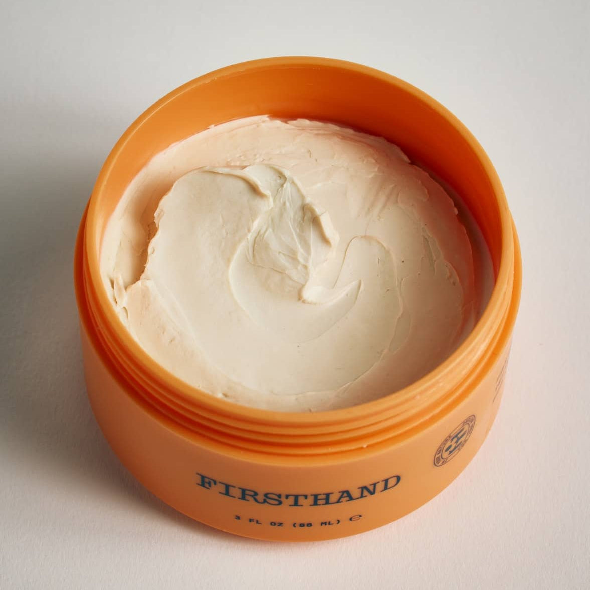 Orange container of Firsthand Supply Texturizing Paste on a light gray background